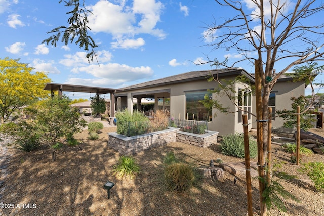 rear view of property featuring stucco siding