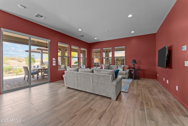 living room with visible vents, wood finished floors, baseboards, and recessed lighting