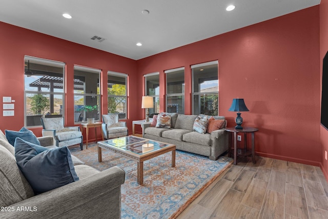 living room featuring recessed lighting, visible vents, and wood finished floors