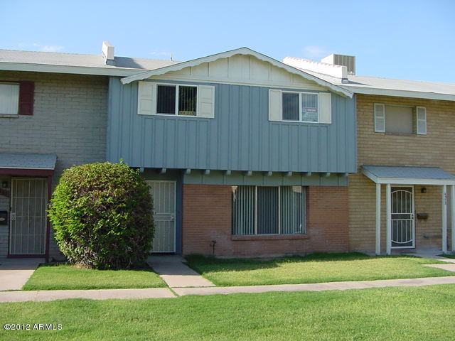 multi unit property featuring brick siding, board and batten siding, and a front yard
