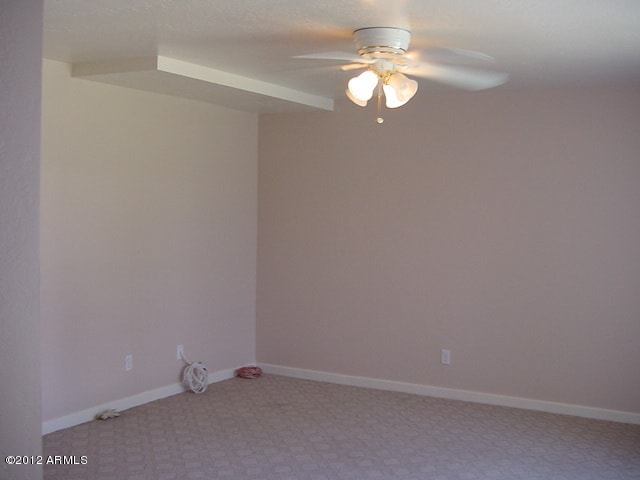 empty room with light colored carpet and ceiling fan