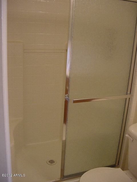 bathroom with a shower stall and toilet