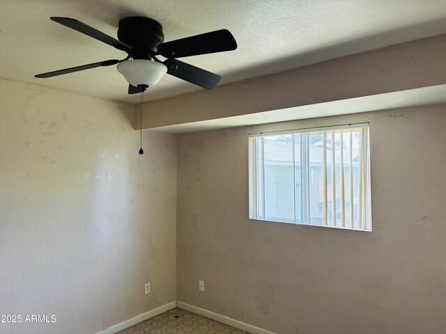 carpeted empty room featuring baseboards and ceiling fan