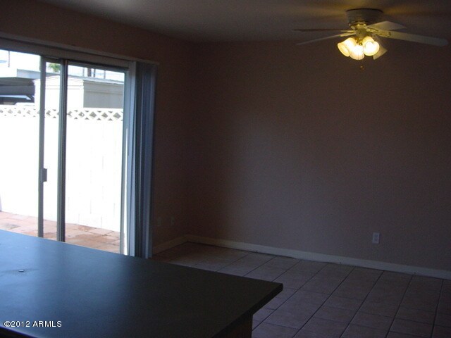 unfurnished dining area with baseboards, ceiling fan, and light tile patterned flooring