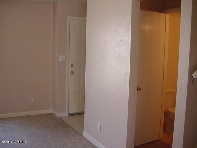 corridor featuring carpet floors and baseboards
