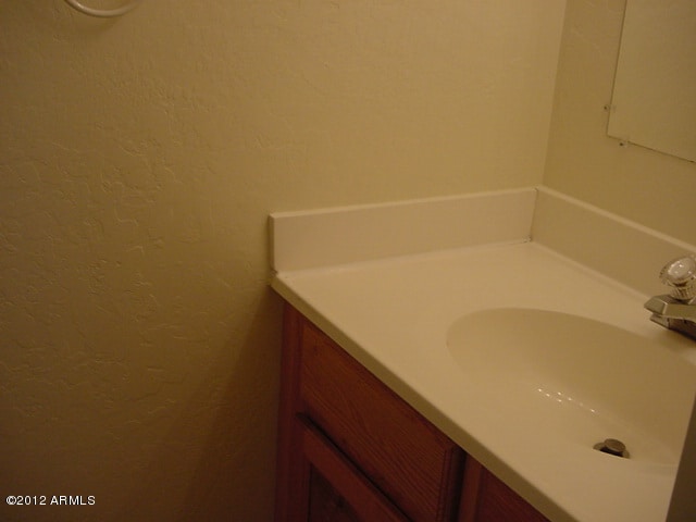 bathroom featuring vanity and a textured wall