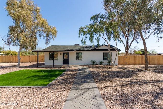 ranch-style house featuring fence