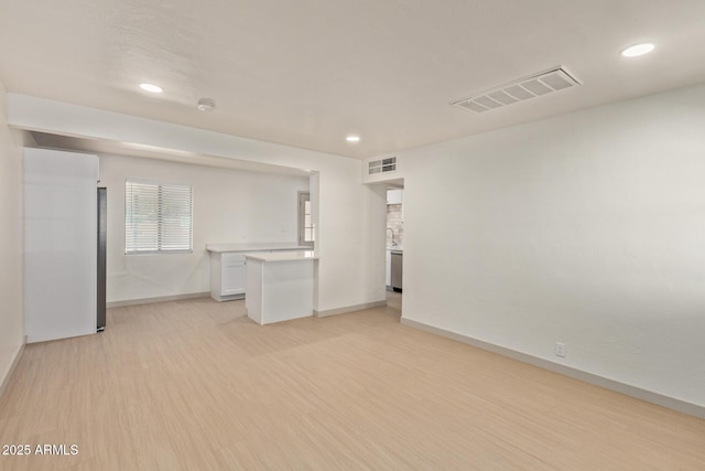 unfurnished living room with light wood finished floors, visible vents, recessed lighting, and baseboards