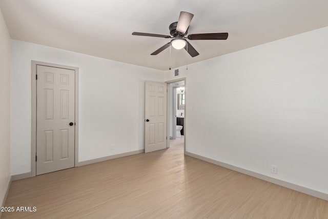 empty room featuring visible vents, baseboards, ceiling fan, and light wood finished floors