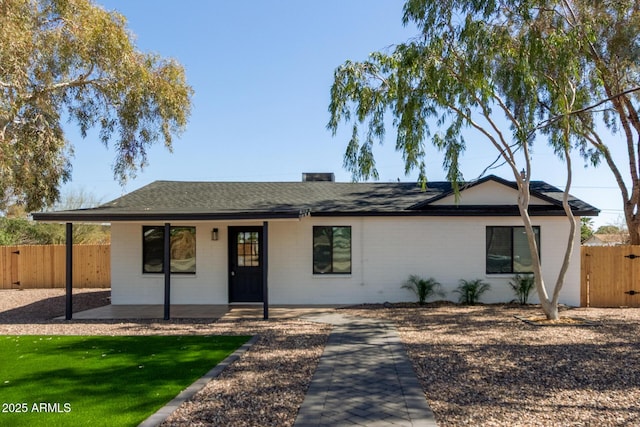 ranch-style house featuring a porch, a gate, fence, and brick siding