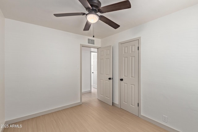 spare room featuring light wood-style flooring, baseboards, visible vents, and ceiling fan