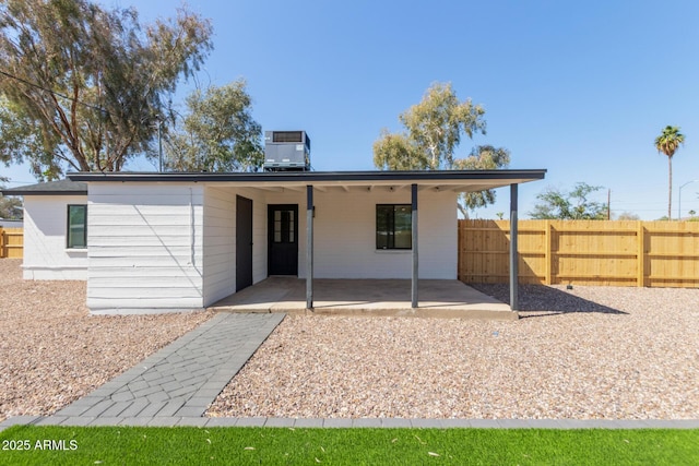 rear view of property with a patio area, central AC unit, and fence