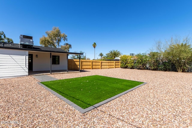 view of yard featuring a patio, central AC, and fence