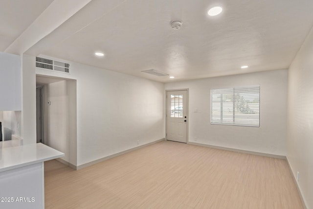 foyer entrance featuring baseboards, visible vents, and light wood finished floors