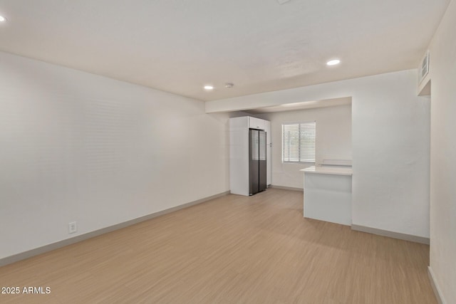 unfurnished room with recessed lighting, baseboards, visible vents, and light wood finished floors