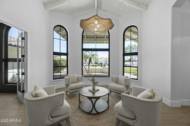 living room with plenty of natural light, baseboards, wood finished floors, and beam ceiling
