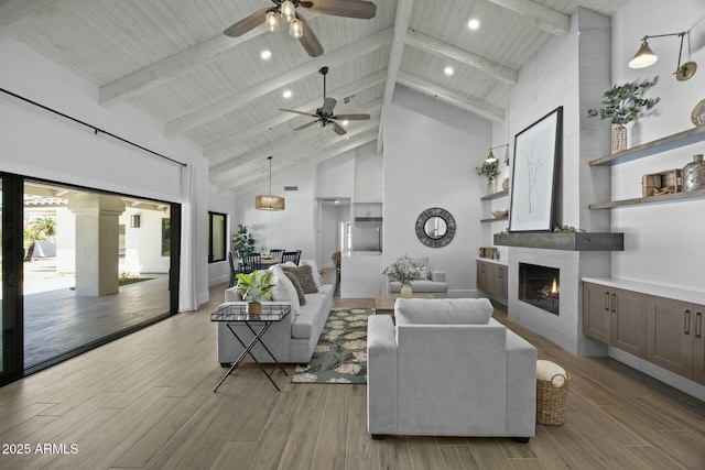 living area with wooden ceiling, a fireplace, a ceiling fan, and light wood finished floors