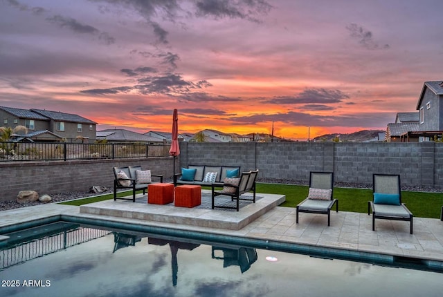 pool at dusk with a patio area and outdoor lounge area