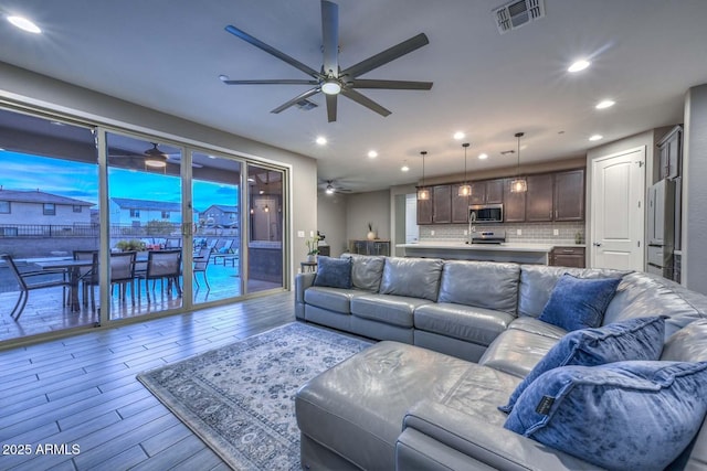 living room featuring ceiling fan and light hardwood / wood-style flooring