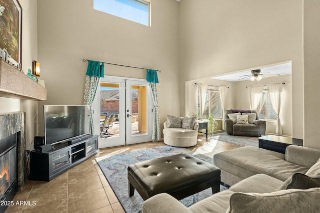 living room with french doors, plenty of natural light, and a towering ceiling