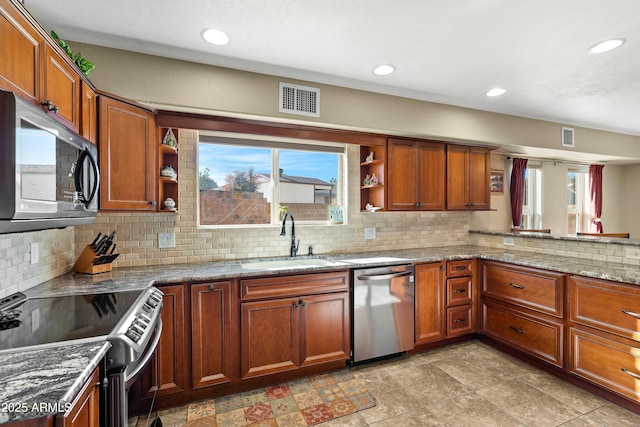 kitchen with sink, backsplash, appliances with stainless steel finishes, and plenty of natural light