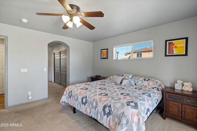 bedroom featuring light carpet, ceiling fan, and a closet