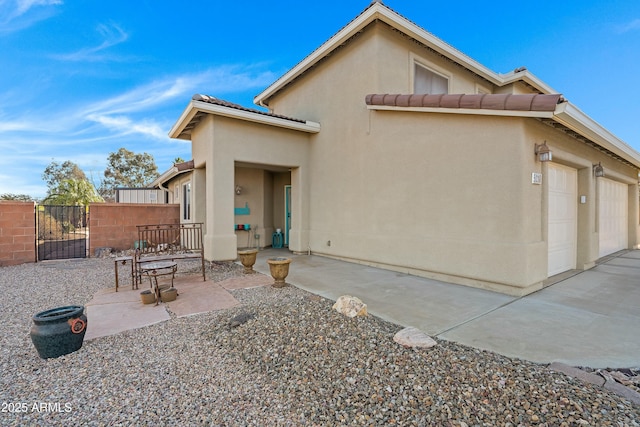 back of house featuring a garage and a patio