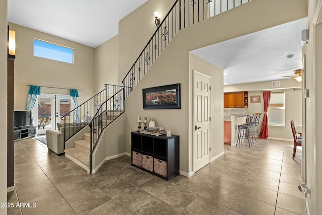 staircase with ceiling fan, tile patterned floors, and french doors