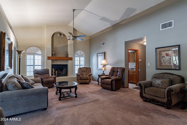 living room with carpet floors, a large fireplace, high vaulted ceiling, and ceiling fan