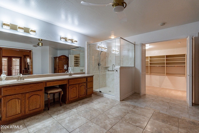 bathroom with walk in shower, vanity, tile patterned floors, and ceiling fan