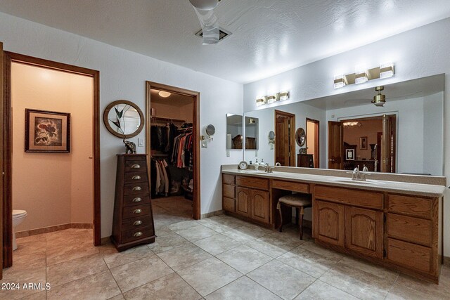 13108 N 76th St, Scottsdale, AZ 85260 - bathroom with double vanity, toilet, a walk in closet, and tile patterned floors