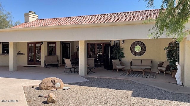 rear view of property with french doors and a patio area