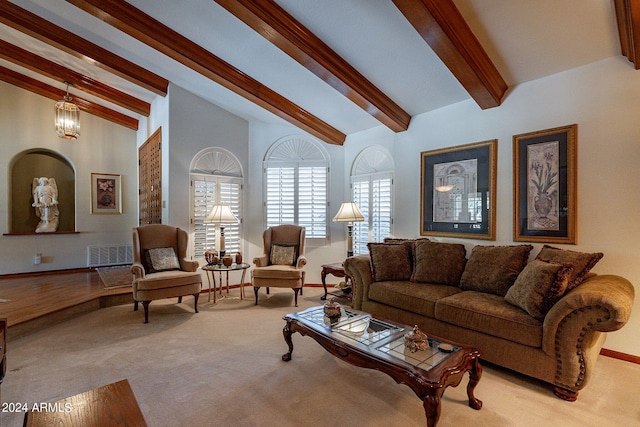 living room with vaulted ceiling with beams, a chandelier, and light colored carpet