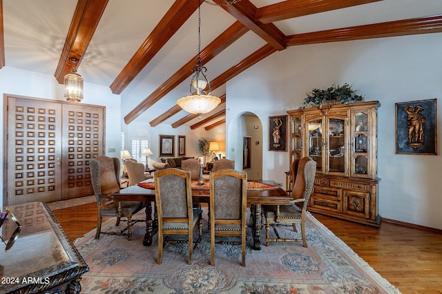 dining area with lofted ceiling with beams and wood-type flooring