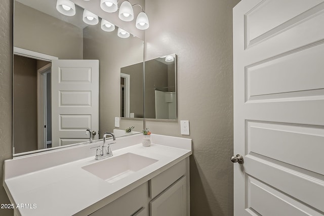 bathroom featuring a textured wall and vanity