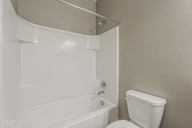 full bath featuring toilet, a textured wall, and shower / washtub combination