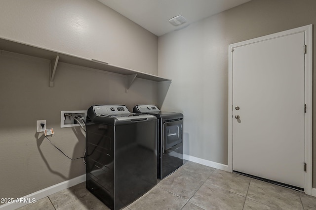 washroom with washer and dryer, baseboards, laundry area, and light tile patterned floors