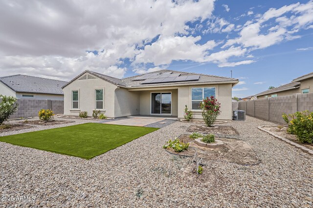 back of house with solar panels, a patio area, a fenced backyard, and stucco siding