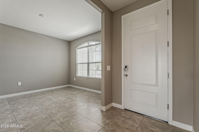 foyer entrance with light tile patterned flooring and baseboards