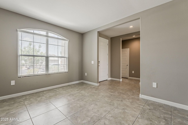 unfurnished room featuring baseboards, light tile patterned flooring, recessed lighting, and a healthy amount of sunlight