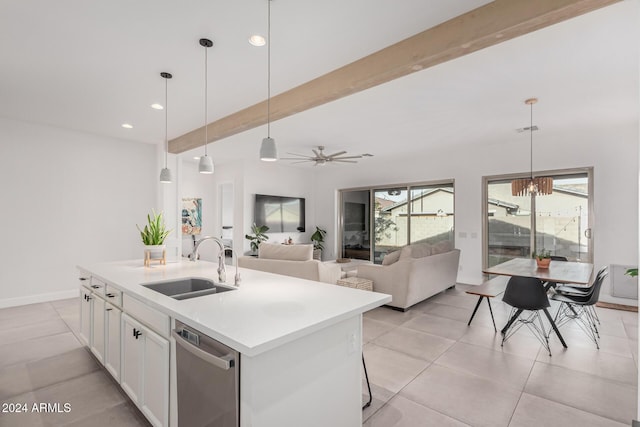 kitchen featuring white cabinetry, sink, stainless steel dishwasher, pendant lighting, and a center island with sink