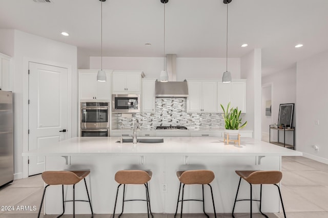 kitchen with decorative light fixtures, stainless steel appliances, a large island, and sink