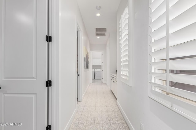 hall featuring light tile patterned floors and washing machine and clothes dryer