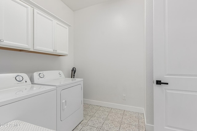 washroom with cabinets, light tile patterned floors, and washer and clothes dryer