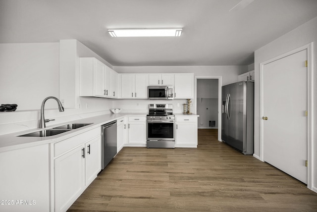 kitchen with sink, light hardwood / wood-style flooring, stainless steel appliances, and white cabinets