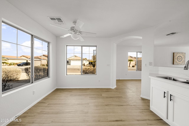 unfurnished dining area featuring ceiling fan, sink, and light hardwood / wood-style flooring