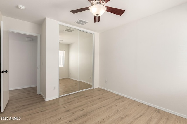 22547 W Pima St, Buckeye, AZ 85326 - unfurnished bedroom with a closet, light wood-style flooring, and a ceiling fan
