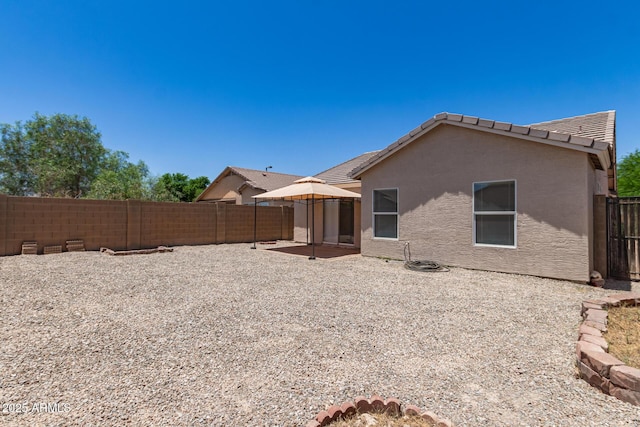 22547 W Pima St, Buckeye, AZ 85326 - back of house with a fenced backyard, stucco siding, a tile roof, and a patio