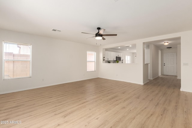 22547 W Pima St, Buckeye, AZ 85326 - unfurnished living room with a ceiling fan, healthy amount of natural light, and light wood-style floors
