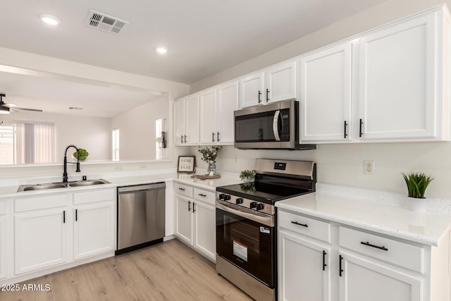 22547 W Pima St, Buckeye, AZ 85326 - kitchen with appliances with stainless steel finishes, white cabinets, light wood-type flooring, a ceiling fan, and recessed lighting
